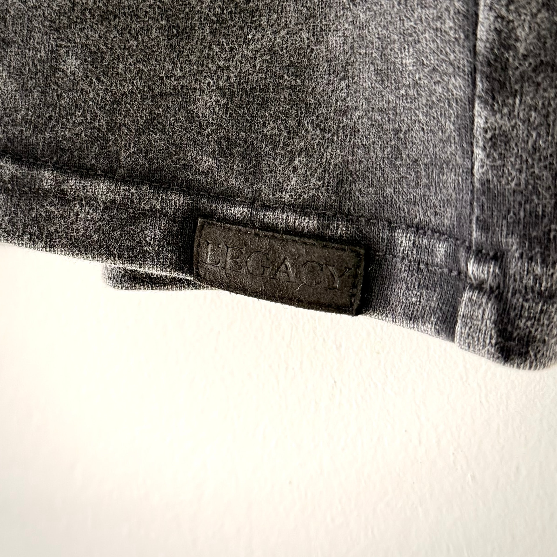 Black embossed L.EGACY hem tag